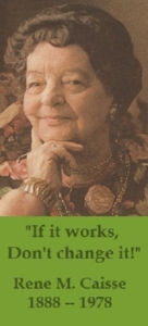 RENE CAISSE POSING IN A FLOWER PATTERN DRESS AND WEARING COSTUME JEWELRY ON A BANNER STATING "IF IT WORKS, DON’T CHANGE IT".