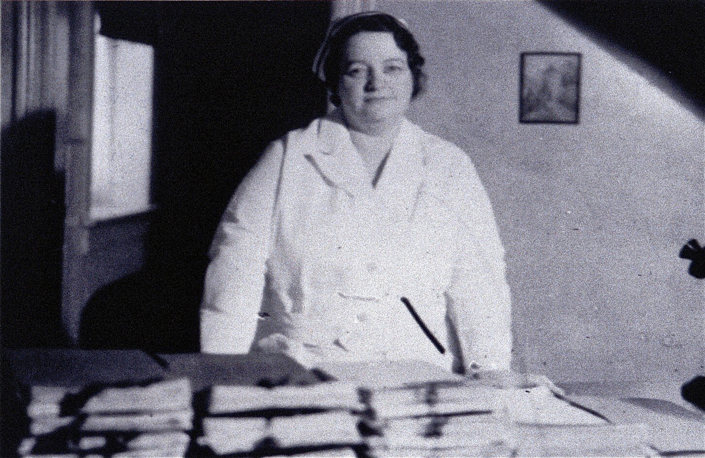 RENE CAISSE IN NURSE’S UNIFORM STANDING  BEHIND DESK WITH STACKS OF PETITIONS  FOR THE ONTARIO LEGISLATURE TO MAKE ESSIAC A LEGAL CANCER TREATMENT