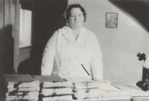 NURSE RENE M. CAISSE STANDING BEHIND HER DESK WITH STACKS OF PETITIONS TO MAKE ESSIAC A LEGAL TREATMENT FOR CANCER IN ONTARIO CANADA